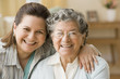 Hispanic mother and adult daughter hugging