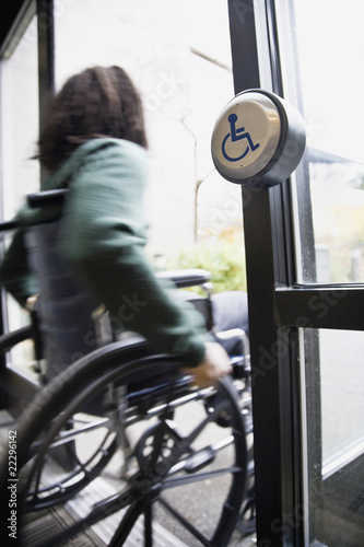 Photo: African man in wheelchair using automatic door African man in wheelchair using automatic door