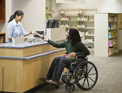 Photo: African man in wheelchair at library African man in wheelchair at library
