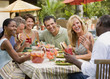 Multi-ethnic couples eating outdoors