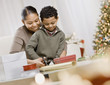 Mixed Race mother and son wrapping Christmas gifts