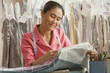 Asian female dry cleaner checking ticket