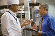 Hispanic businessman talking to chef