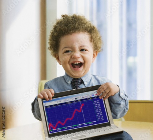 Foto: Mixed Race baby holding laptop with graph Mixed Race baby holding laptop with graph
