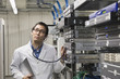 Asian man listening to computer server with stethoscope