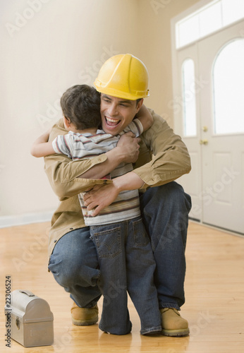 Photo: Hispanic construction worker hugging son Hispanic construction worker hugging son