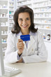 Hispanic pharmacist holding insurance card