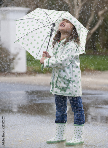 Photo: Mixed race girl with umbrella in rain Mixed race girl with umbrella in rain
