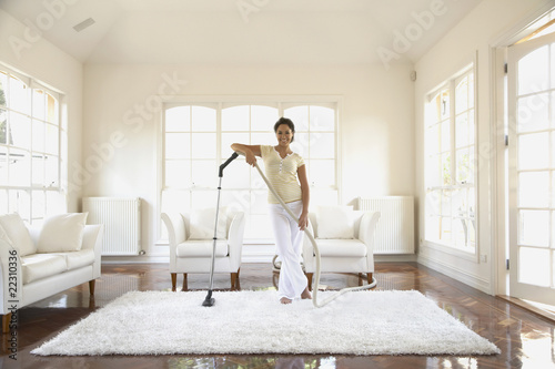Photo: Hispanic woman vacuuming floor Hispanic woman vacuuming floor