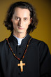Photo: Praying priest with wooden cross reading Bible Praying priest with wooden cross reading Bible