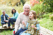 Photo: Grandfather And Granddaughter Blowing Bubbles On Family Picnic Grandfather And Granddaughter Blowing Bubbles On Family Picnic