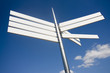 sign pointing in different directions against a blue sky