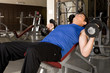 Young man lifting weights in a gym