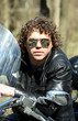 Fashionable biker with curly hair sitting on his motorcycle Fashionable biker with curly hair sitting on his motorcycle
