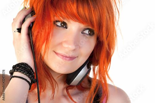 Photo: Redhead young woman holding headphones dancing Redhead young woman holding headphones dancing