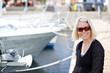 Foto: Blonde woman smiling in yacht harbour Blonde woman smiling in yacht harbour