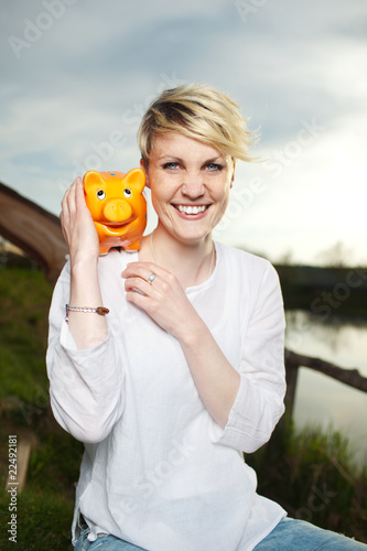 Photo: junge frau mit sparschwein junge frau mit sparschwein