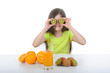 Girl shows kiwi slices sitting at the table Girl shows kiwi slices sitting at the table