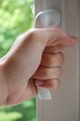 Hand am Fenstergriff