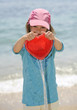 Photo: Young girl playing with bucket at the beach Young girl playing with bucket at the beach