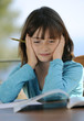 Photo: Young girl (9 years old) reading textbook Young girl (9 years old) reading textbook