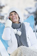 Young woman using mobile phone in snow