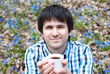 Smiling man drinking coffee on nature