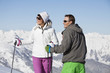 Young couple of skiers looking away