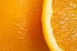 Orange, eine angeschnittene Partie vor einer ganzen Frucht.