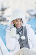 Young woman using mobile phone in snow