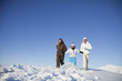 Couple and daughter in ski wear walking in snow