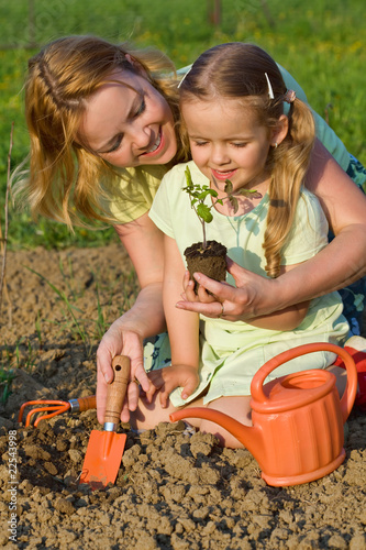 Photo: Woman and little girl growing healthy food Woman and little girl growing healthy food