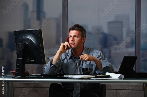 Photo: Businessman on call working overtime Businessman on call working overtime