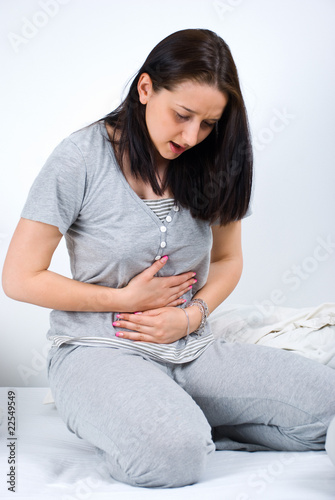 Photo: Woman stomachache in bed Woman stomachache in bed