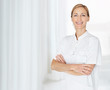 Confident mature female nurse standing with a smile