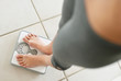Photo: Low section of a dieting woman weighing herself Low section of a dieting woman weighing herself