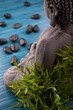Buddha mit Bambus, Massage Steinen und Schale mit Blüten