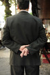 liar: businessman with fingers crossed behind his back