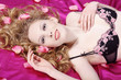 Junge brünette Beauty mit Rosenblätter im Bett, quer 02