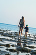 Mum and the son walk on a coast