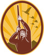 Hunter aiming rifle shotgun upward with ducks and geese