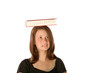 Teen girl balancing text book on her head