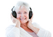 Smiling senior woman listening music with headphones