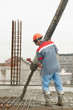 builder worker pouring concrete into form