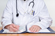 Doctor is writing at the table