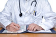 Doctor is writing at the table