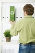 Young man pulling out green folder Young man pulling out green folder