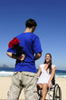 man hiding red roses, a gift for his handicapped girlfriend
