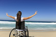 Photo: happy woman in wheelchair outdoors beach showing victory sign happy woman in wheelchair outdoors beach showing victory sign