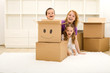 Happy kids and woman having fun in their new home